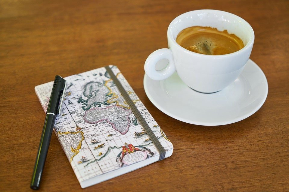 libreta pequeña con café. formas en las que el Bullet Journal te ayuda a lograr tus objetivos