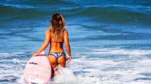 chica haciendo surf en la playa. horóscopo junio 2021